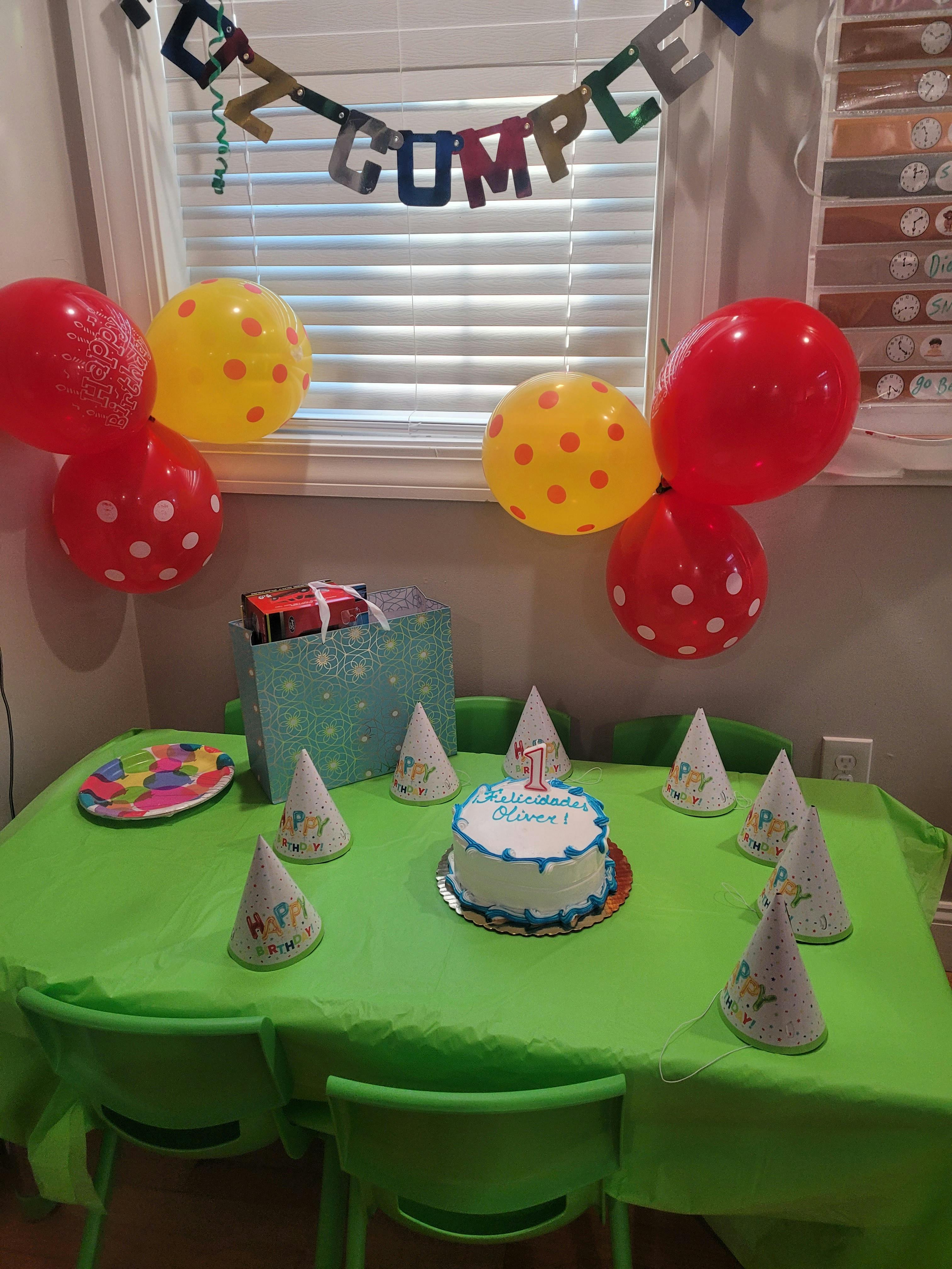 birthday party scene with balloons, cake, party hats, and gifts