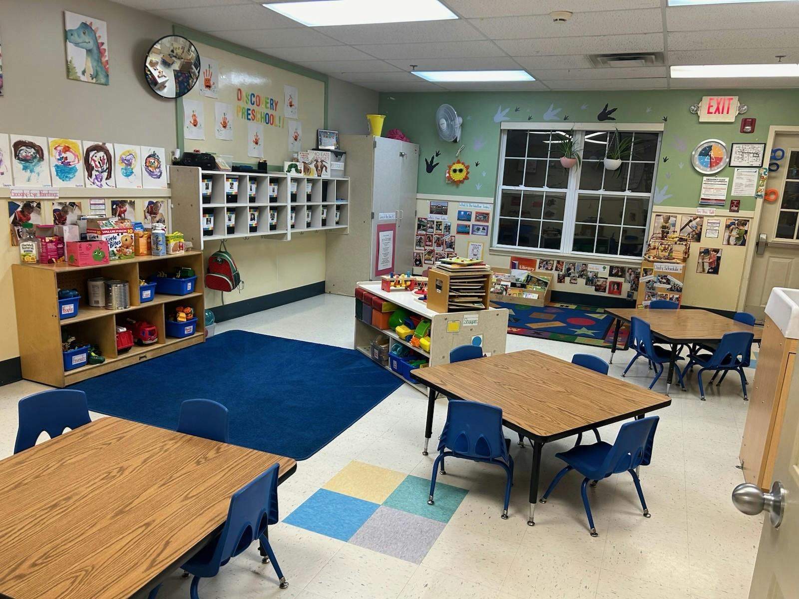 A classroom with small tables and chairs, shelves, and colorful decorations