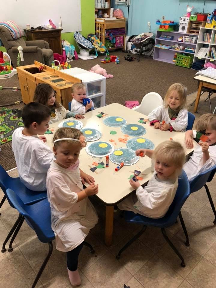 Children sitting around a table doing crafts