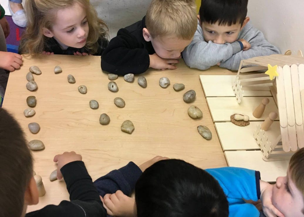 Children looking at rocks arranged on a table