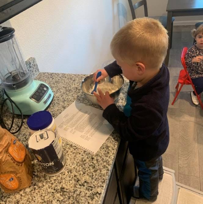 Child mixing ingredients in a bowl in a kitchen