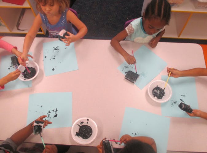 Children doing an art activity with paint and paper