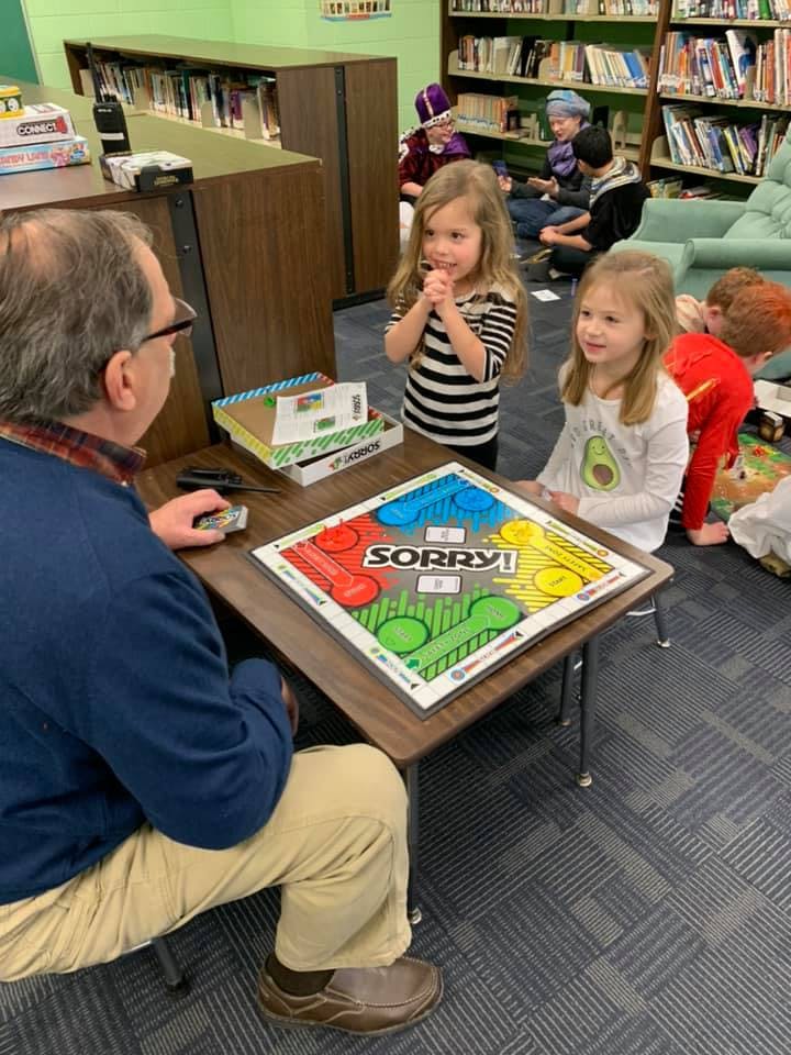 Adult and two children playing the board game Sorry!