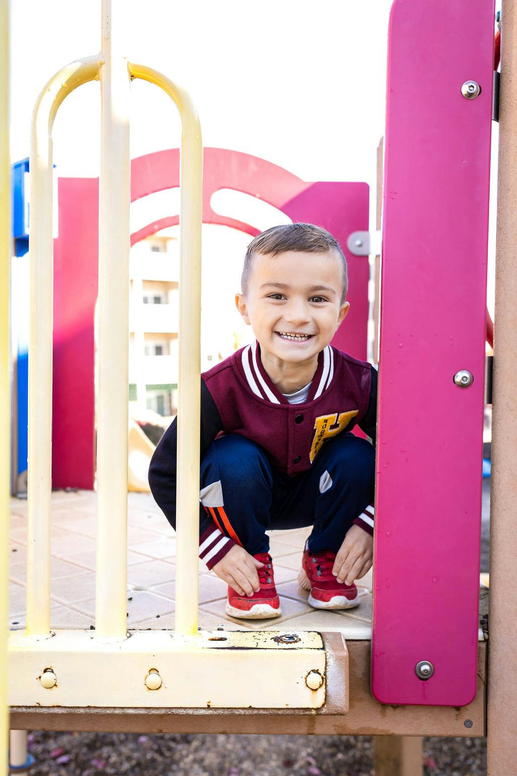 Child crouching on a playground structure