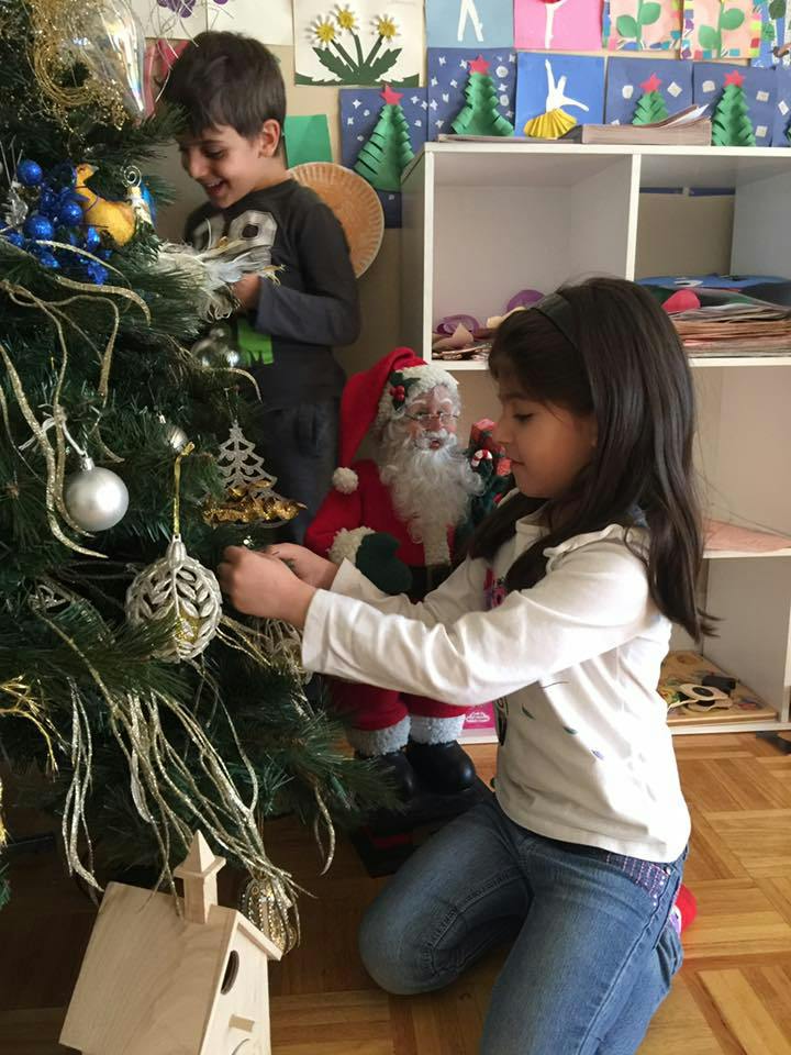 Two children decorating a Christmas tree