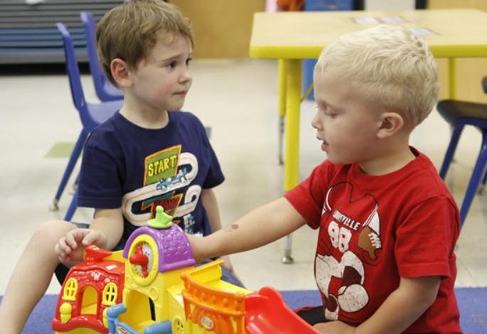 Two children playing with a colorful toy