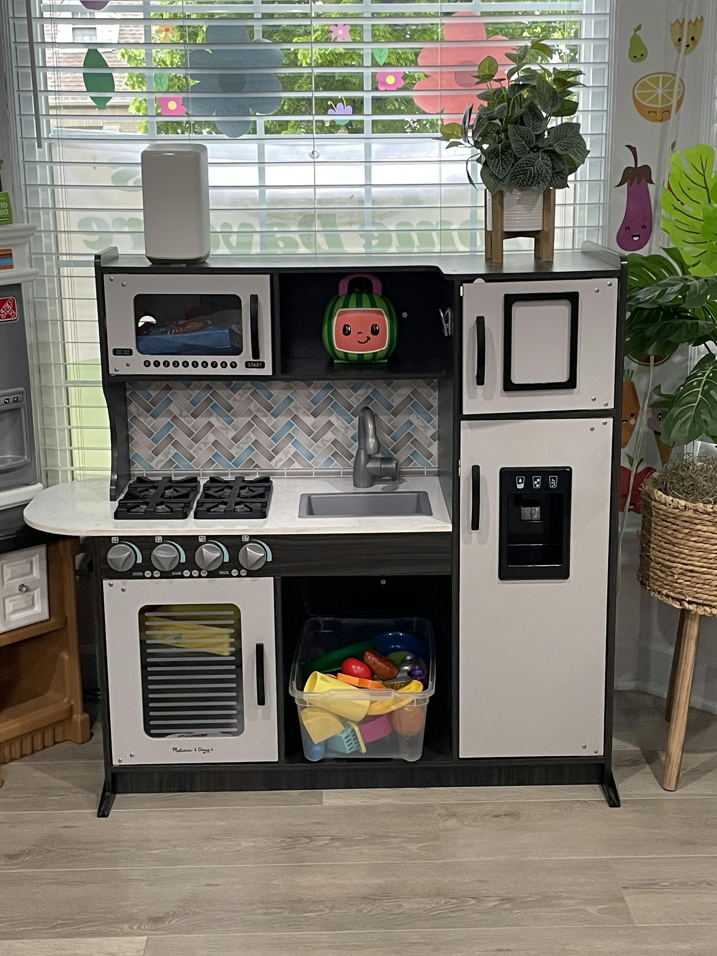 children's play kitchen with a microwave, stove, oven, sink, and refrigerator