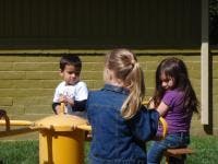 Three children playing on a merry-go-round