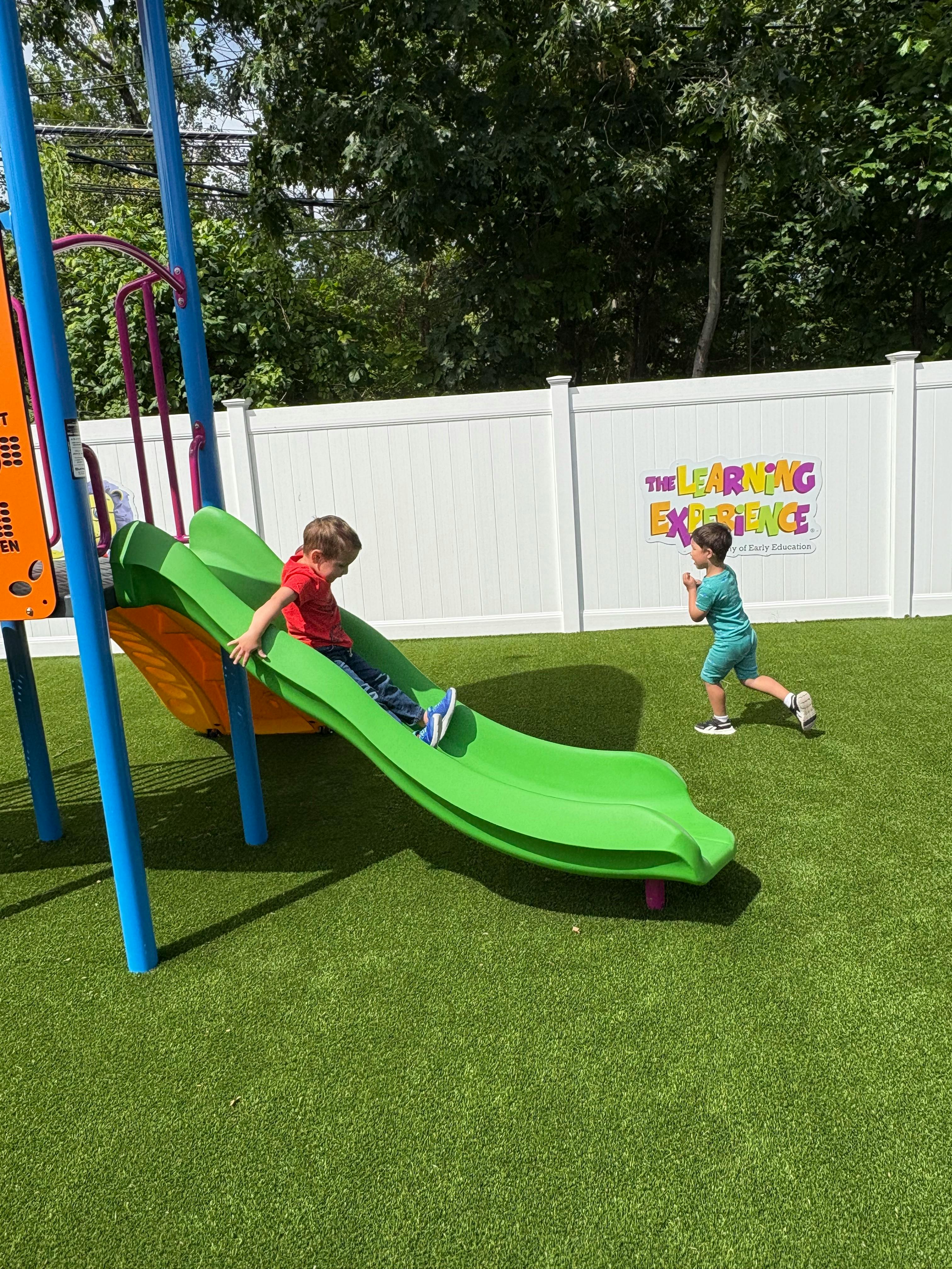 Two children playing on a playground slide