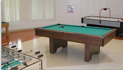Pool table, foosball table, and air hockey table in a room