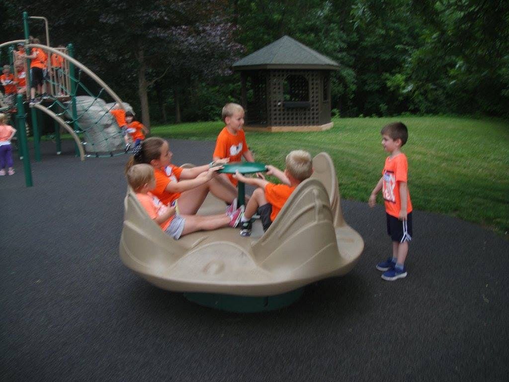 Children playing on a spinning playground ride
