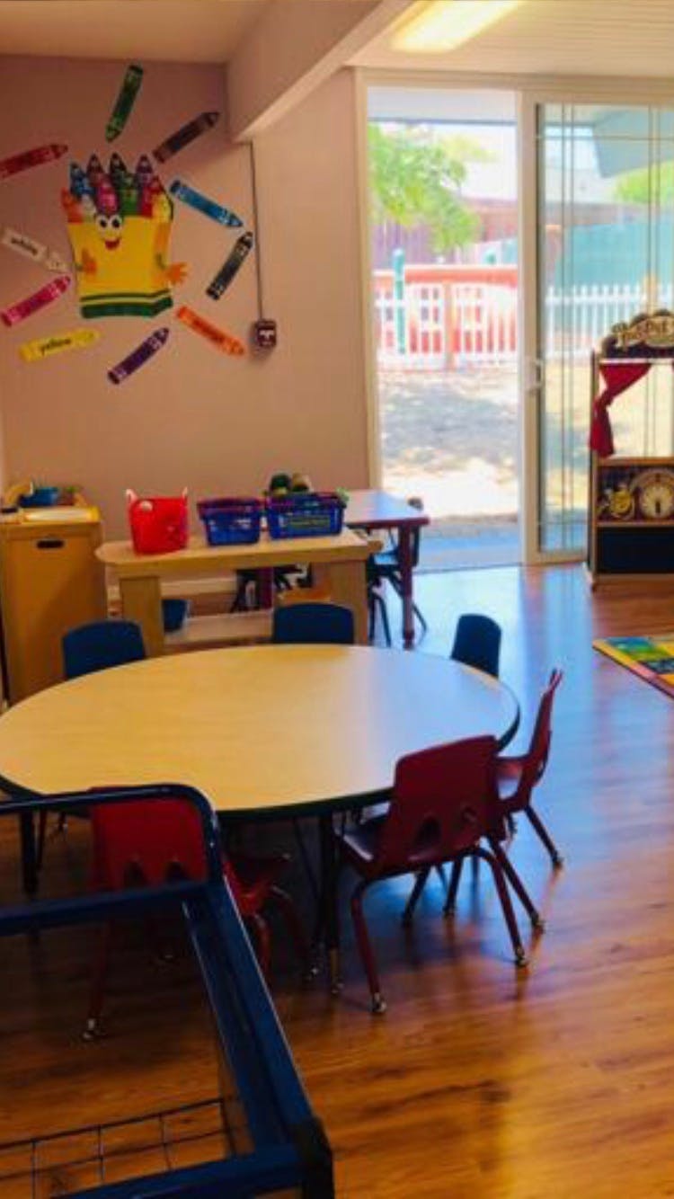 Classroom with tables and chairs, crayon decorations on the wall