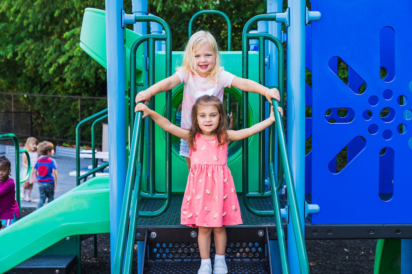 Two children standing on playground equipment