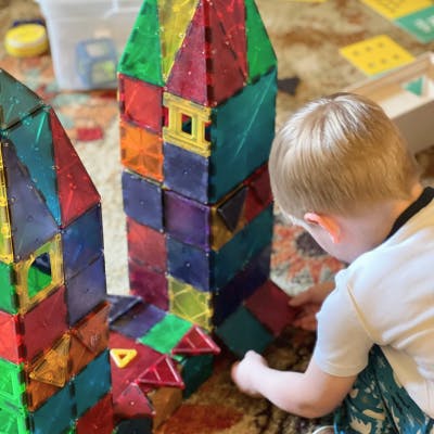 Child building a tower with colorful magnetic tiles