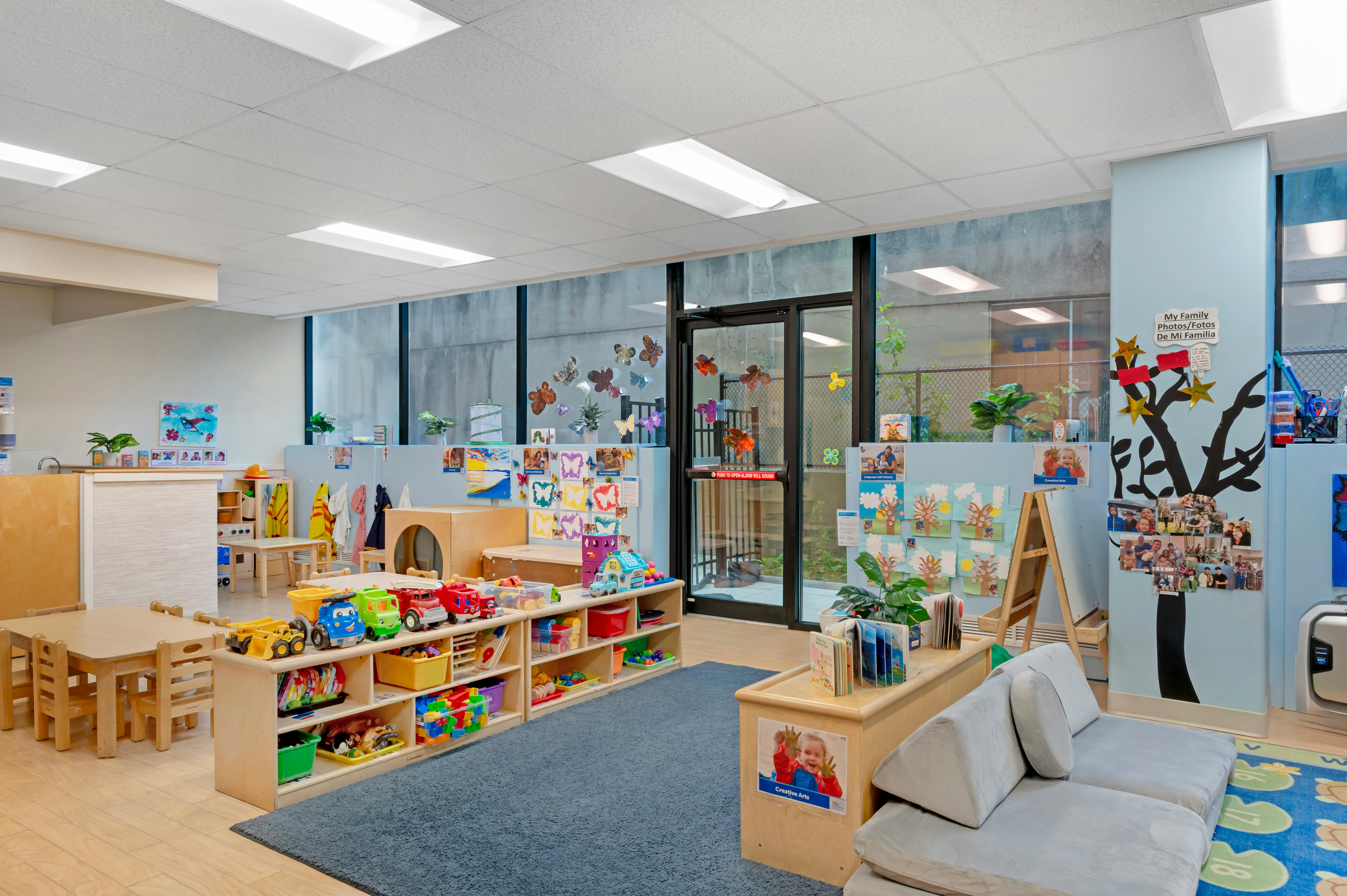 Childcare classroom interior with toy shelves and activity stations