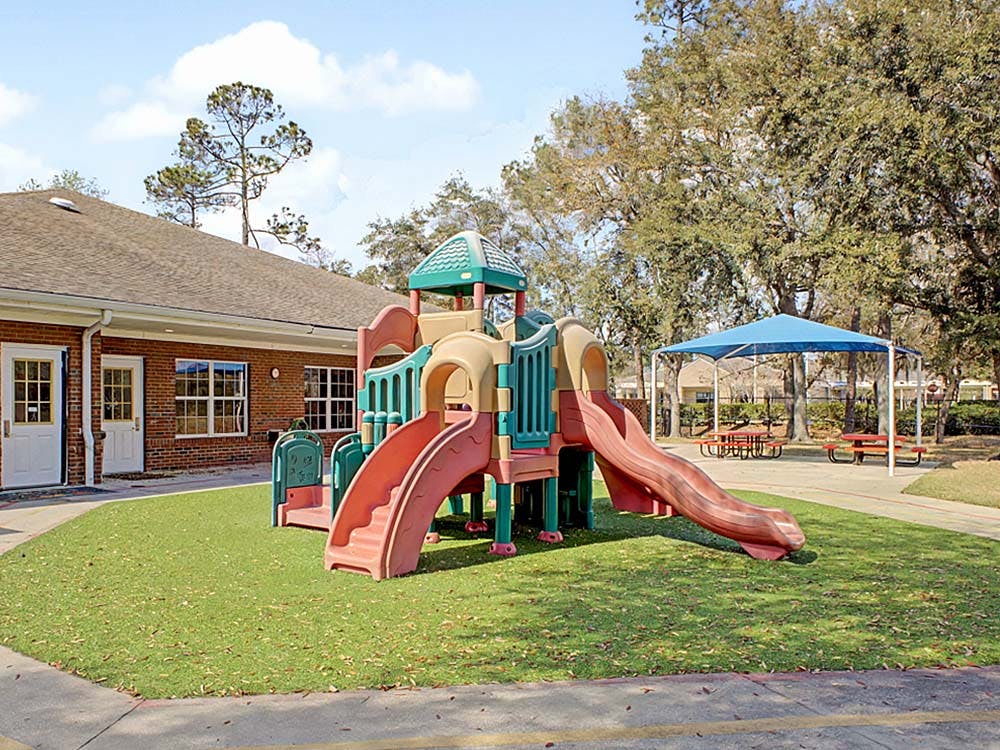 Outdoor playground with slides and a nearby brick building