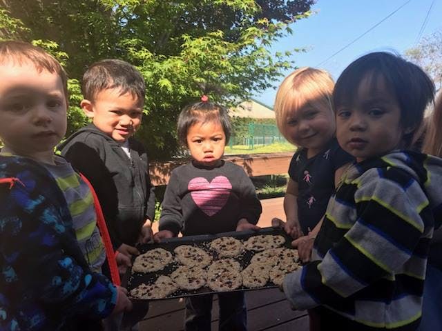 Group of children holding a tray of cookies