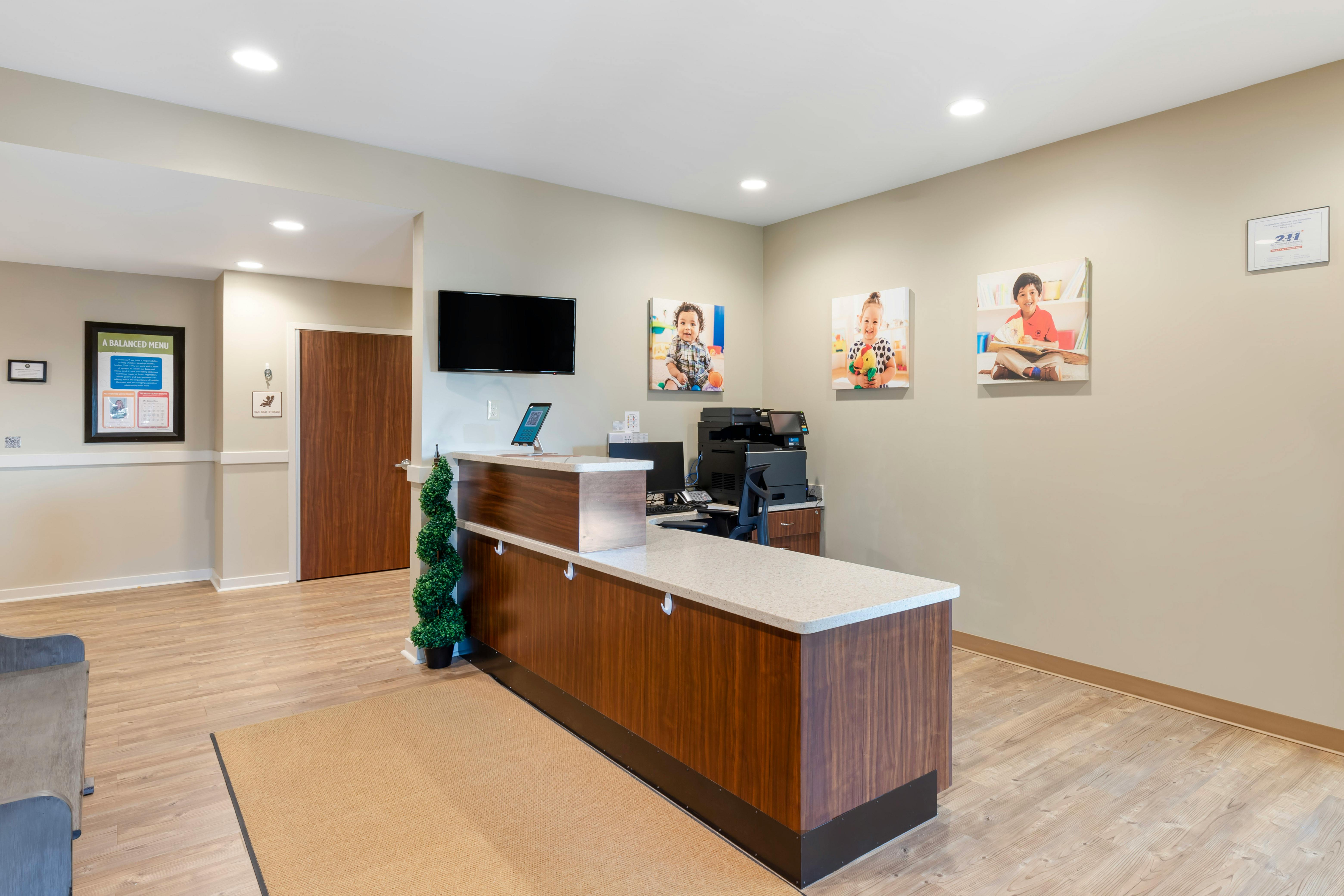 Reception desk with three children's portraits hanging above