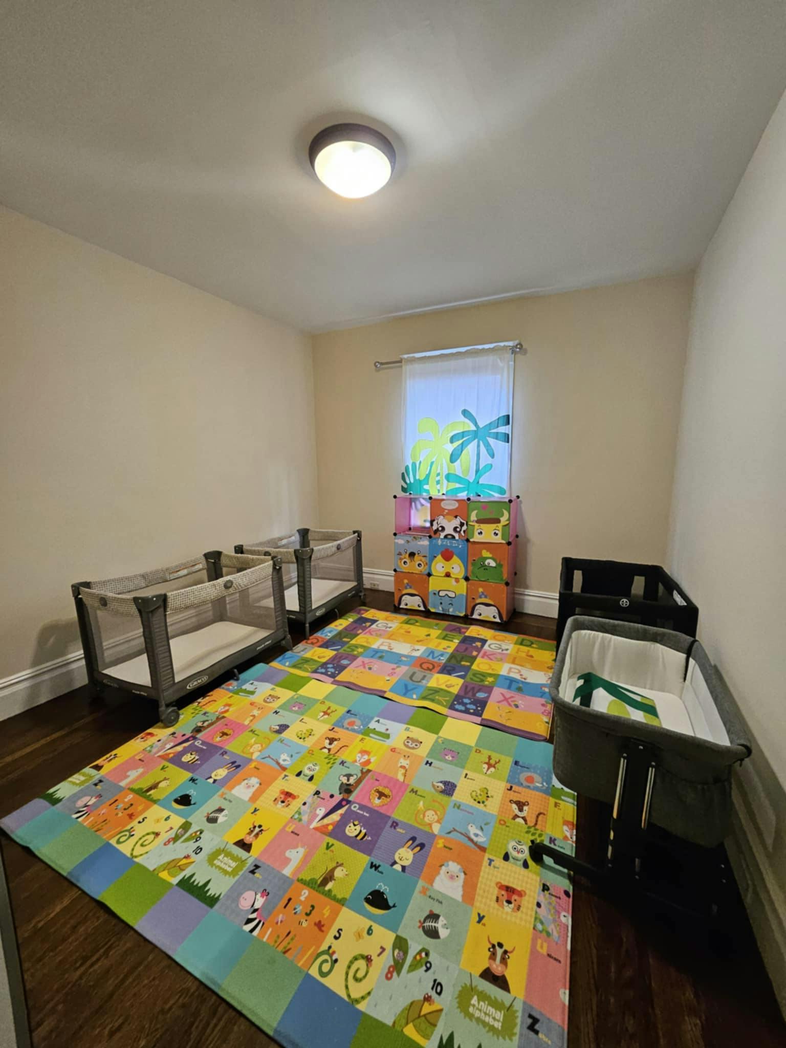 Room with three bassinets and a colorful playmat