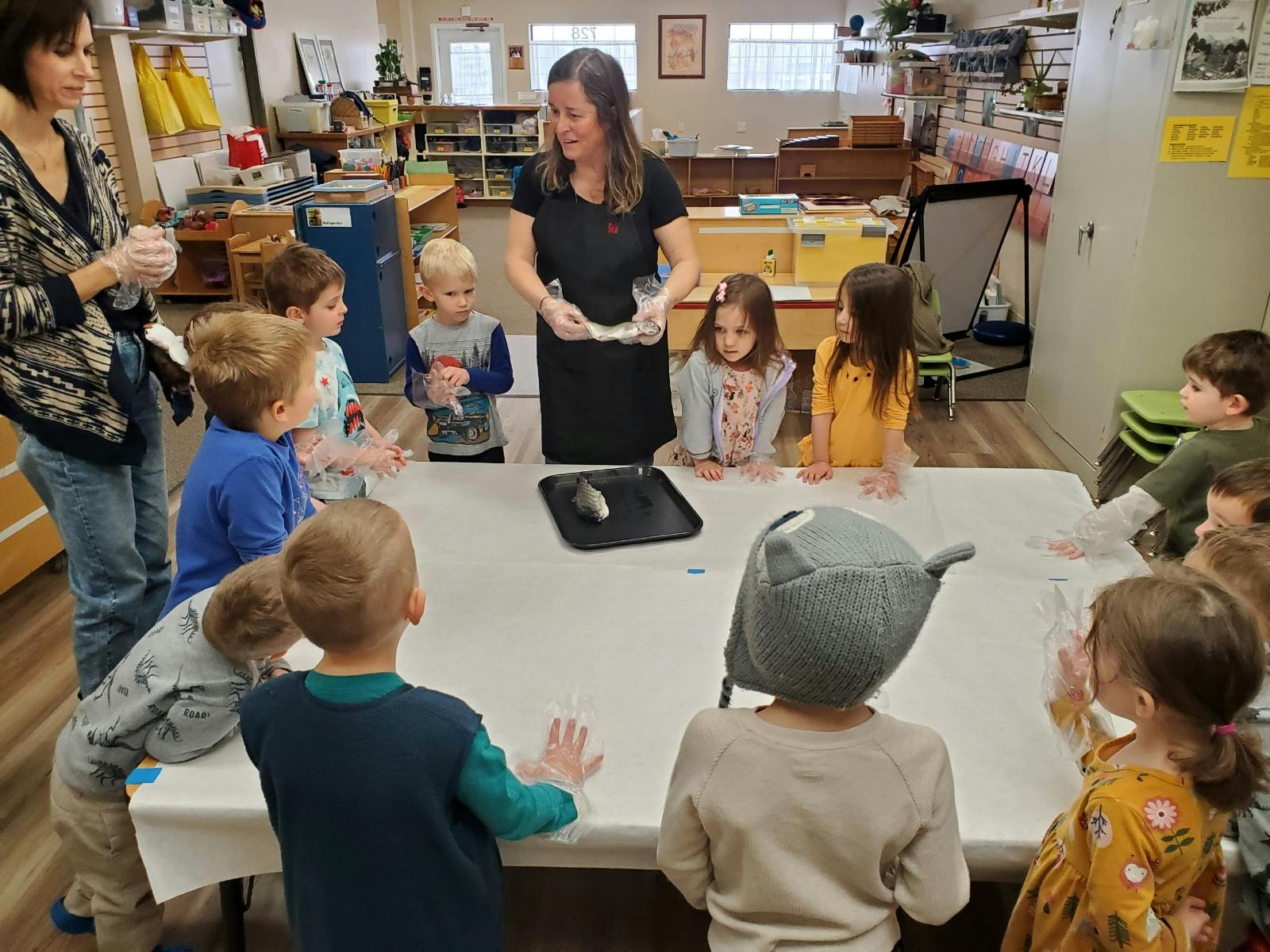Two people and multiple children gathered around a table