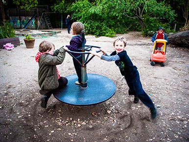 Children playing on a merry-go-round at a playground