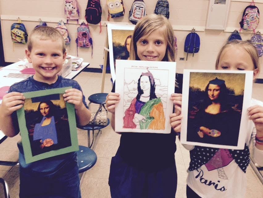 Three children holding up Mona Lisa artwork