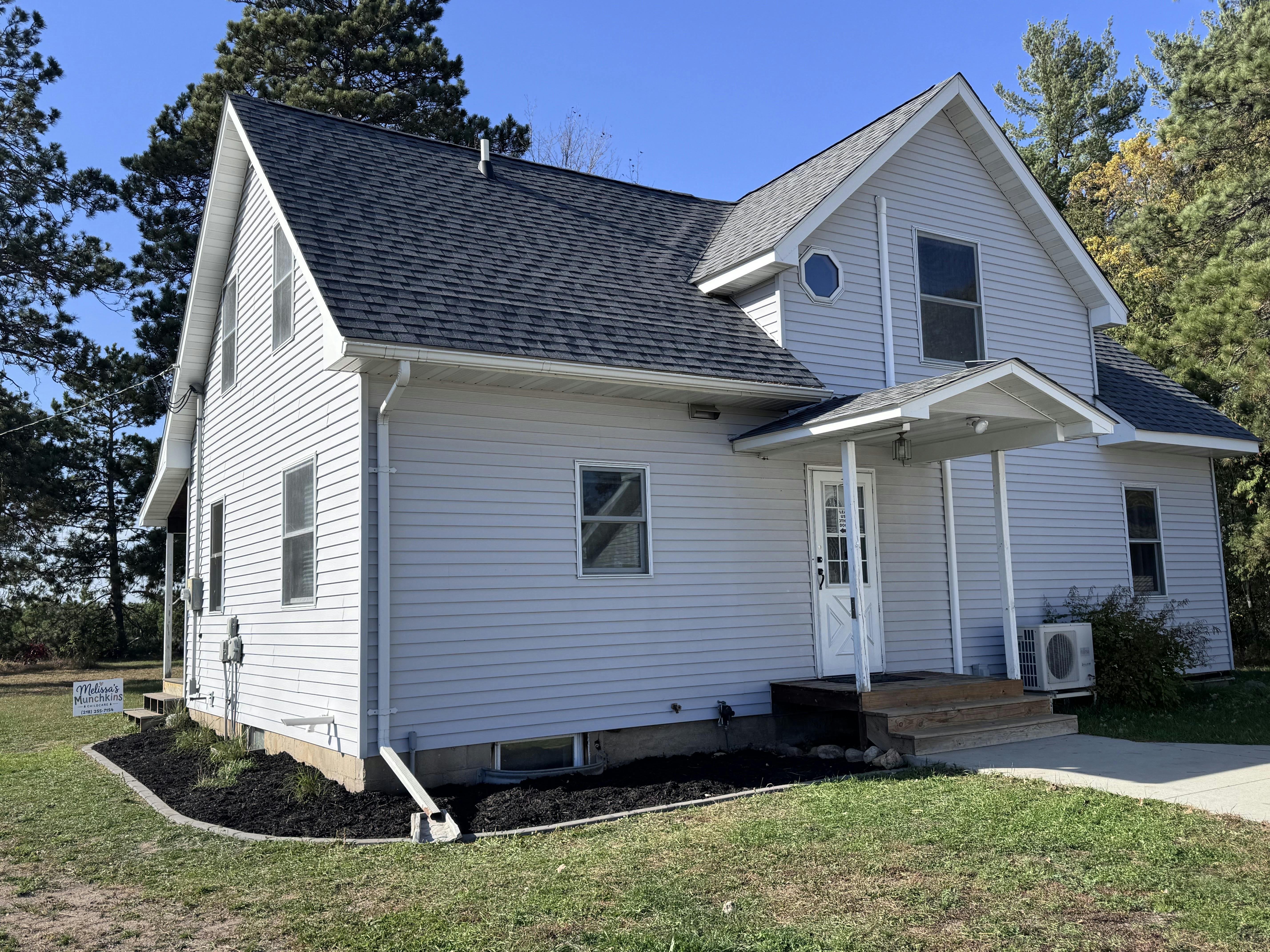 Exterior of a two-story house with siding and a covered front entryway