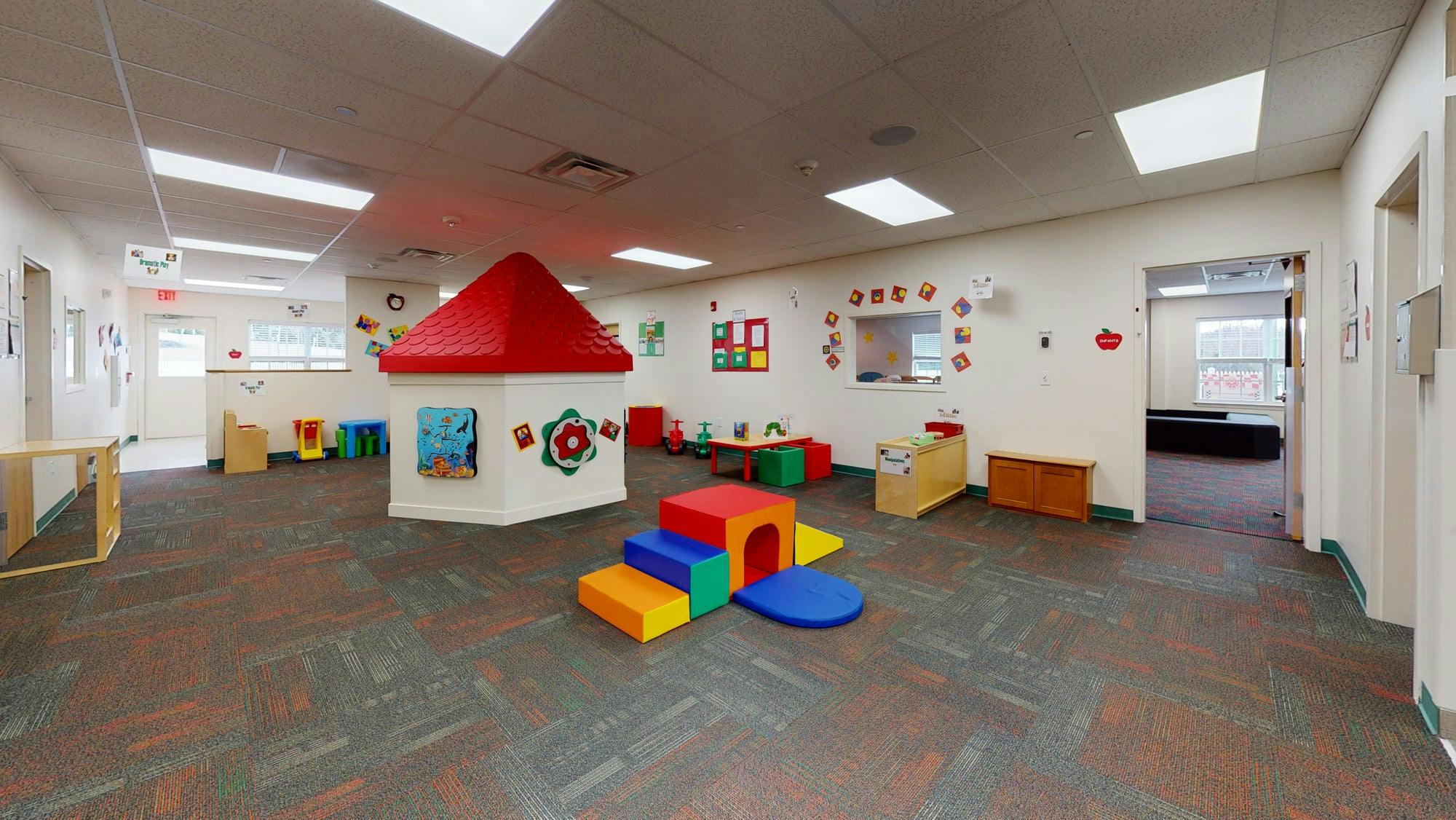 Indoor play area with a playhouse and colorful soft play blocks