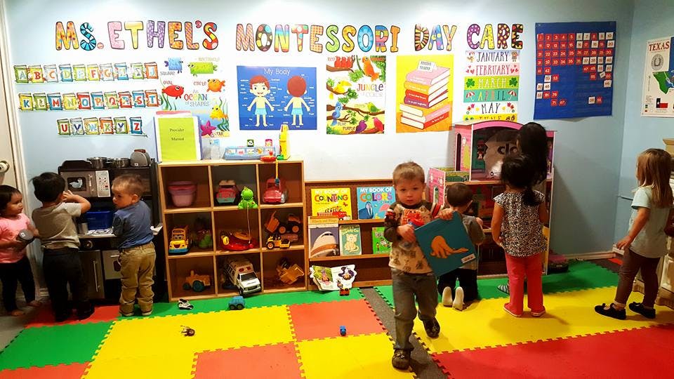 Children playing in a classroom with colorful mats and shelves