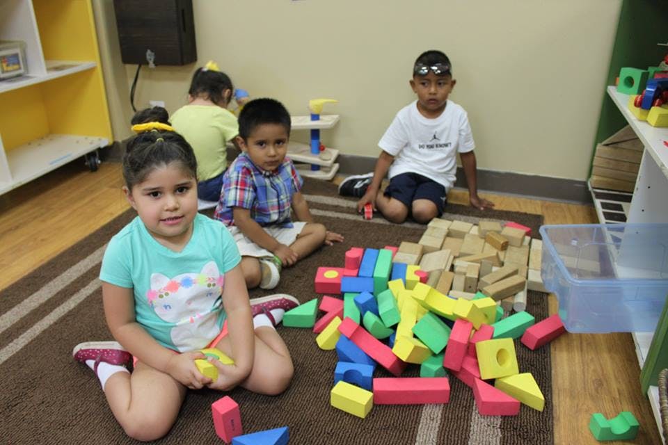 Children playing with blocks on a rug