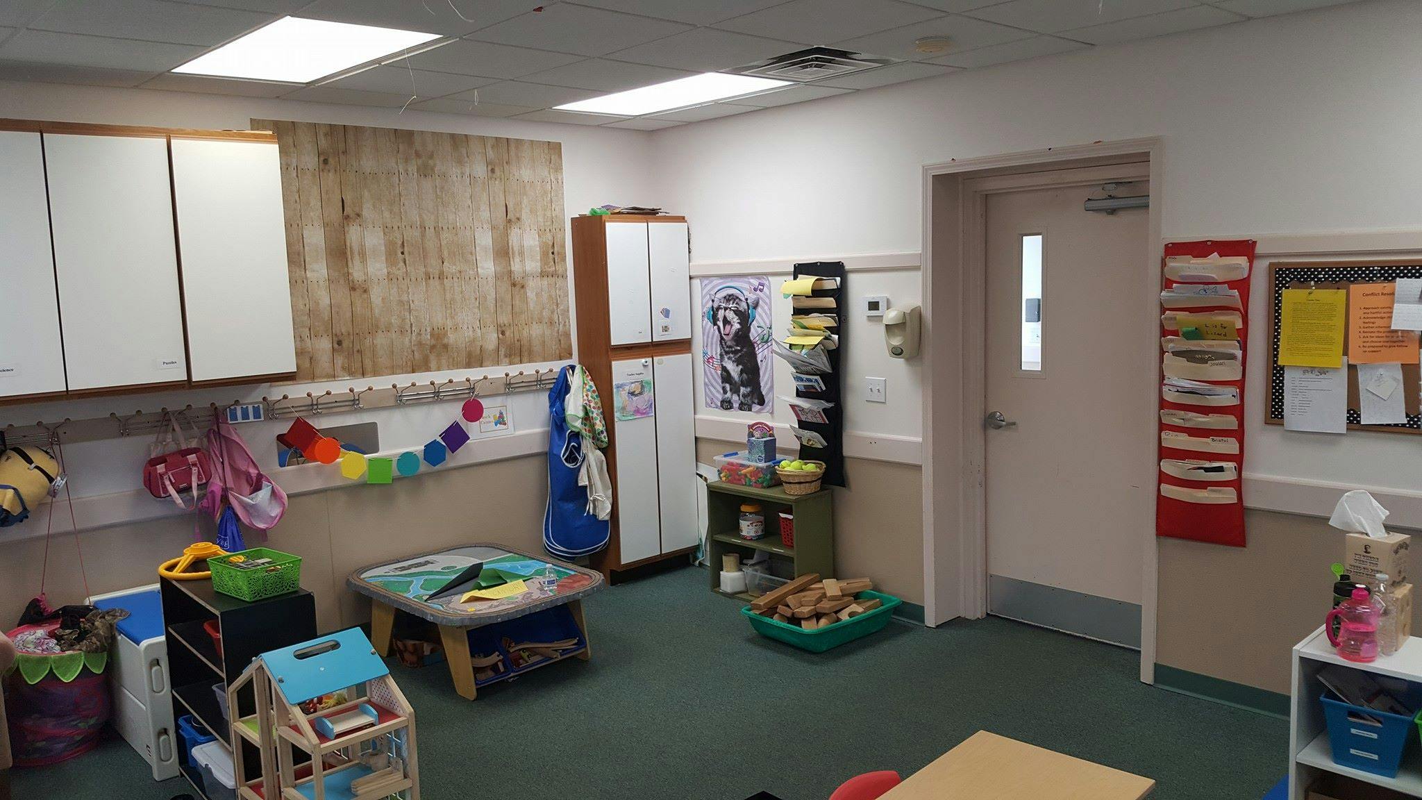 Classroom with cabinets, shelves, and a door
