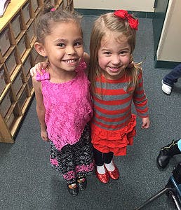 Two children standing together with arms around each other