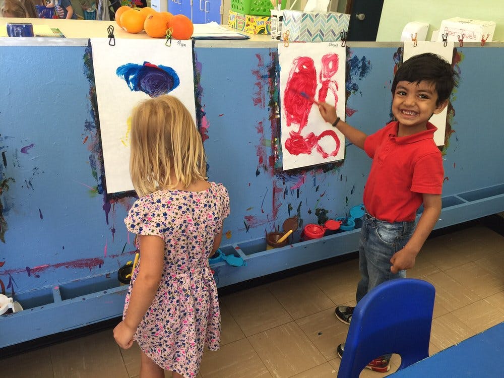 Two children painting at easels