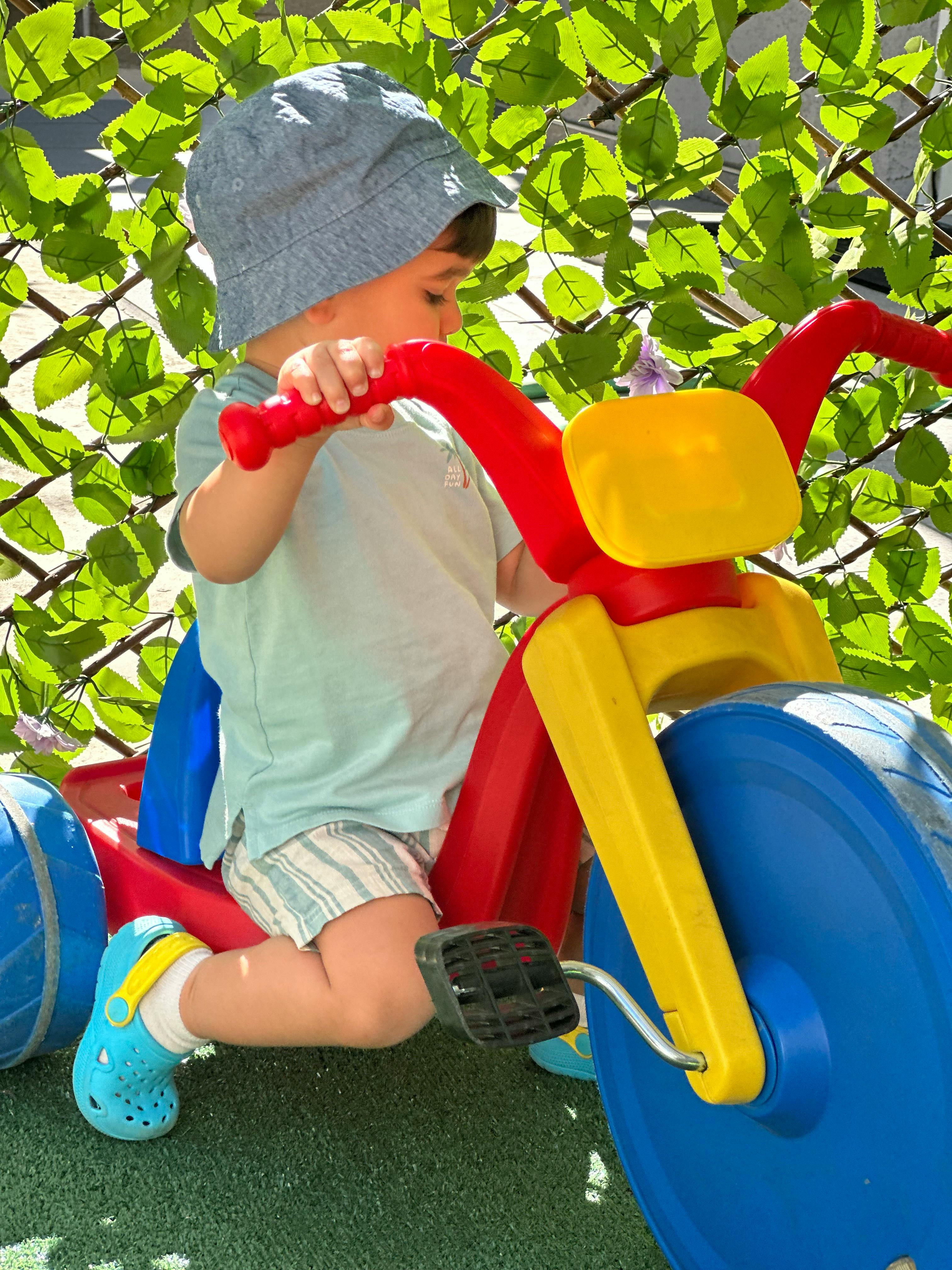 Child riding a colorful plastic tricycle