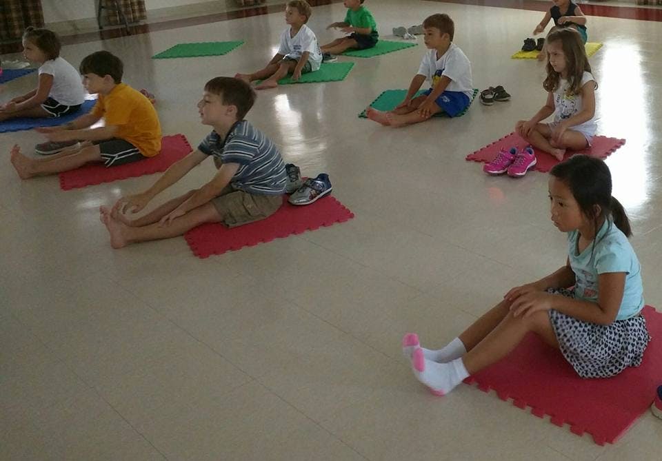 Children stretching on mats in a room