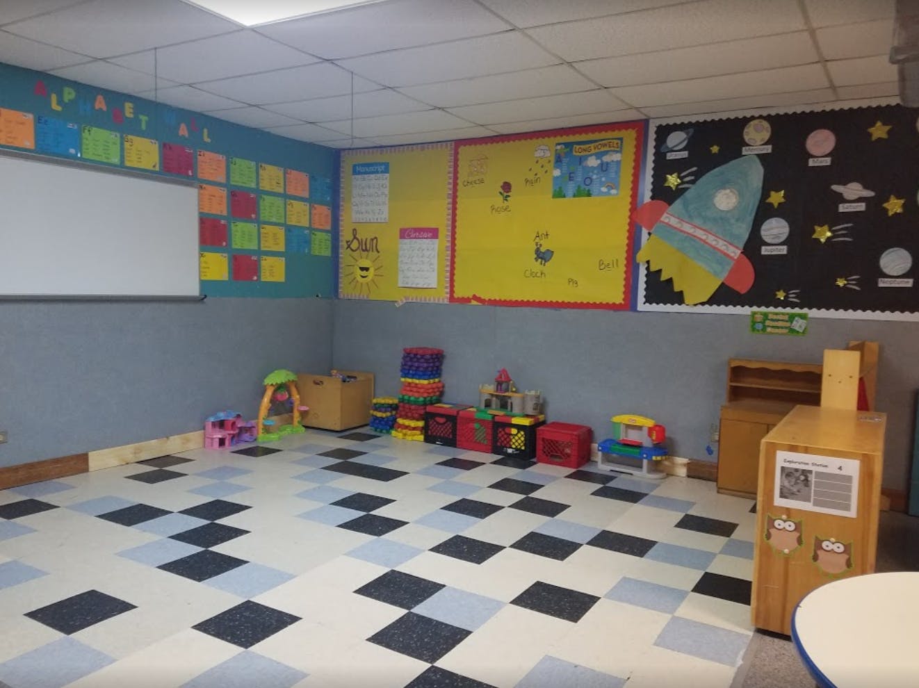 Classroom with colorful bulletin boards and toys on a checkered floor