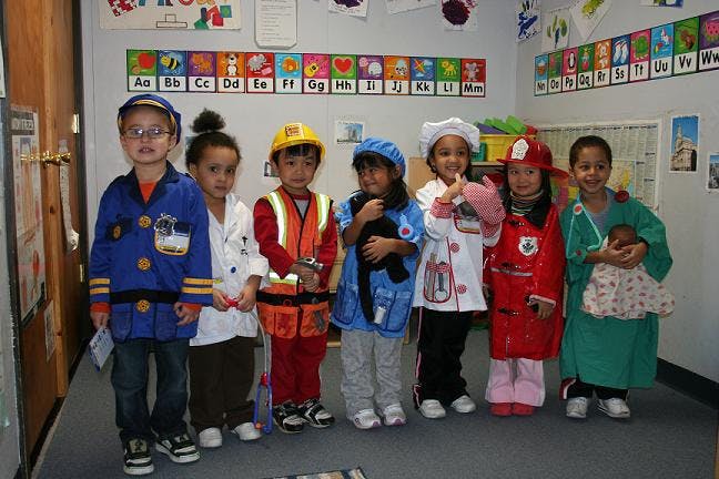 Children in various career costumes in a classroom