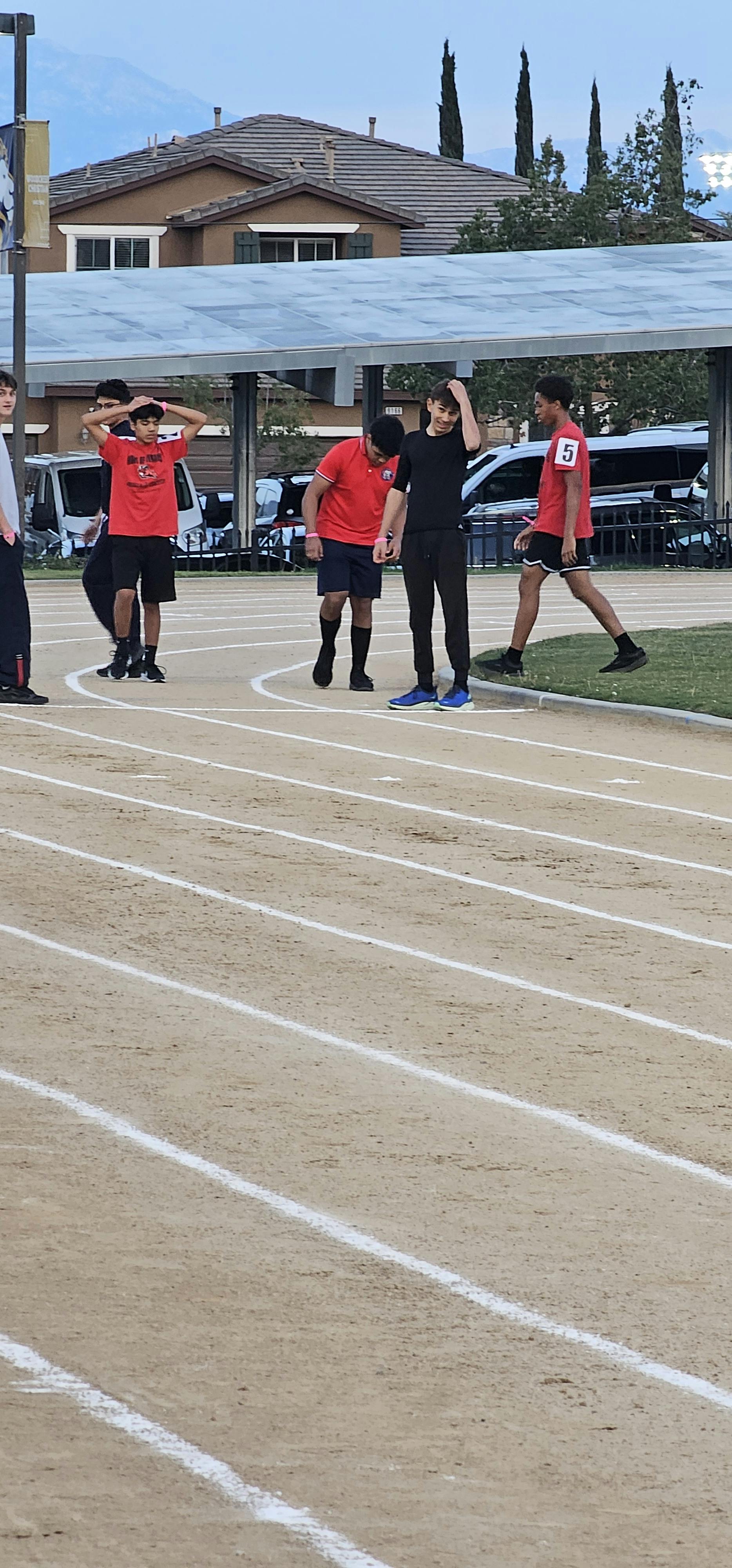 Teens standing on a track field