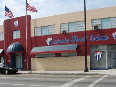 Building with "Lincoln-Mart Schools" sign and American flags