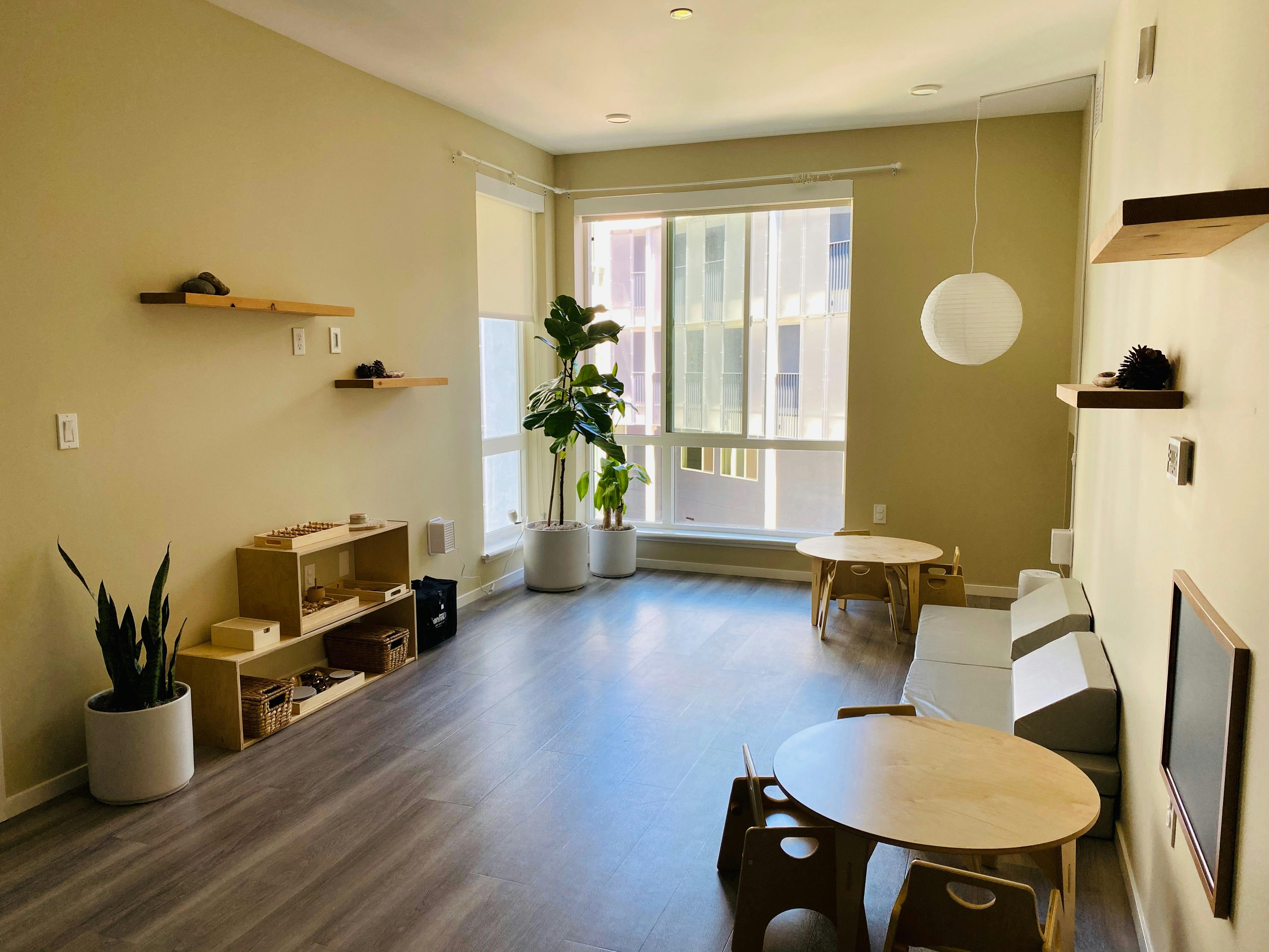 Room with small tables and chairs, shelves, and potted plants