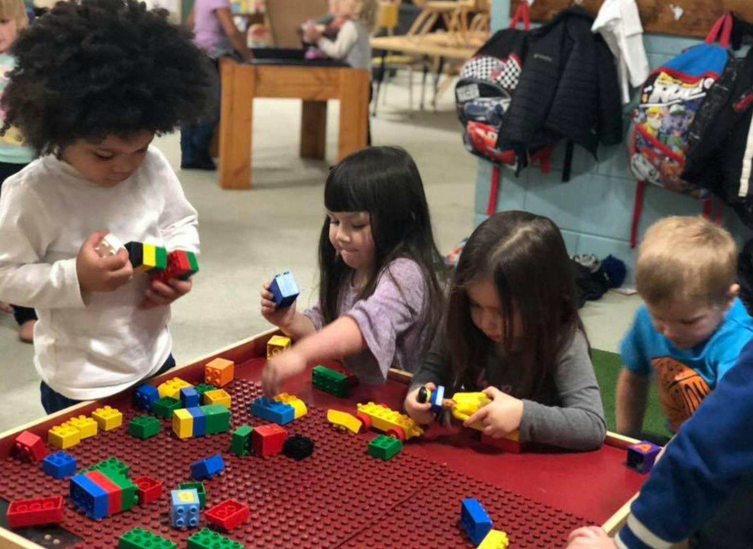 Children playing with colorful building blocks at a table