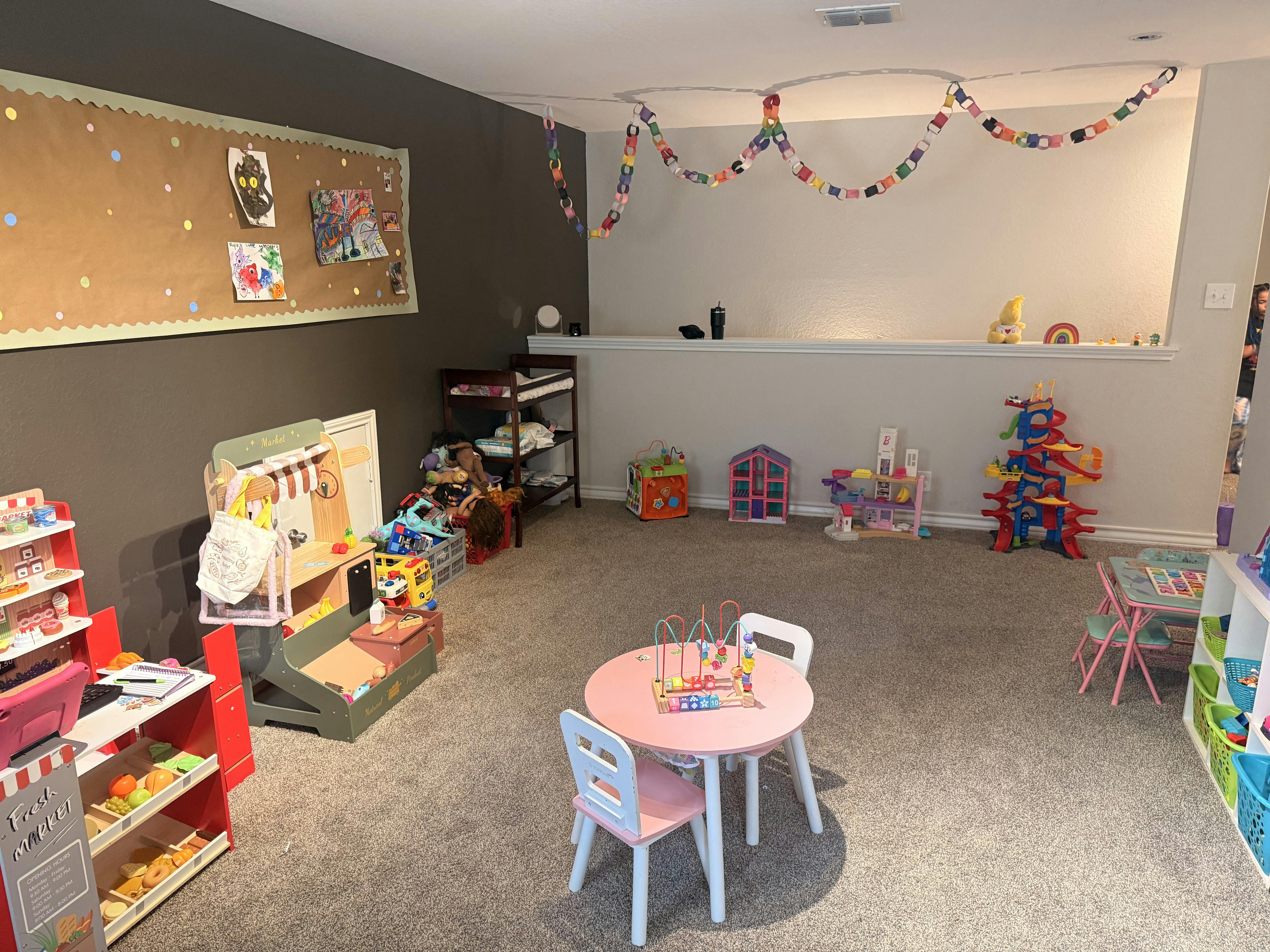 Playroom with children toys including play kitchens and a small activity table