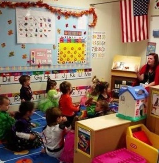 Adult and children sitting on floor in classroom
