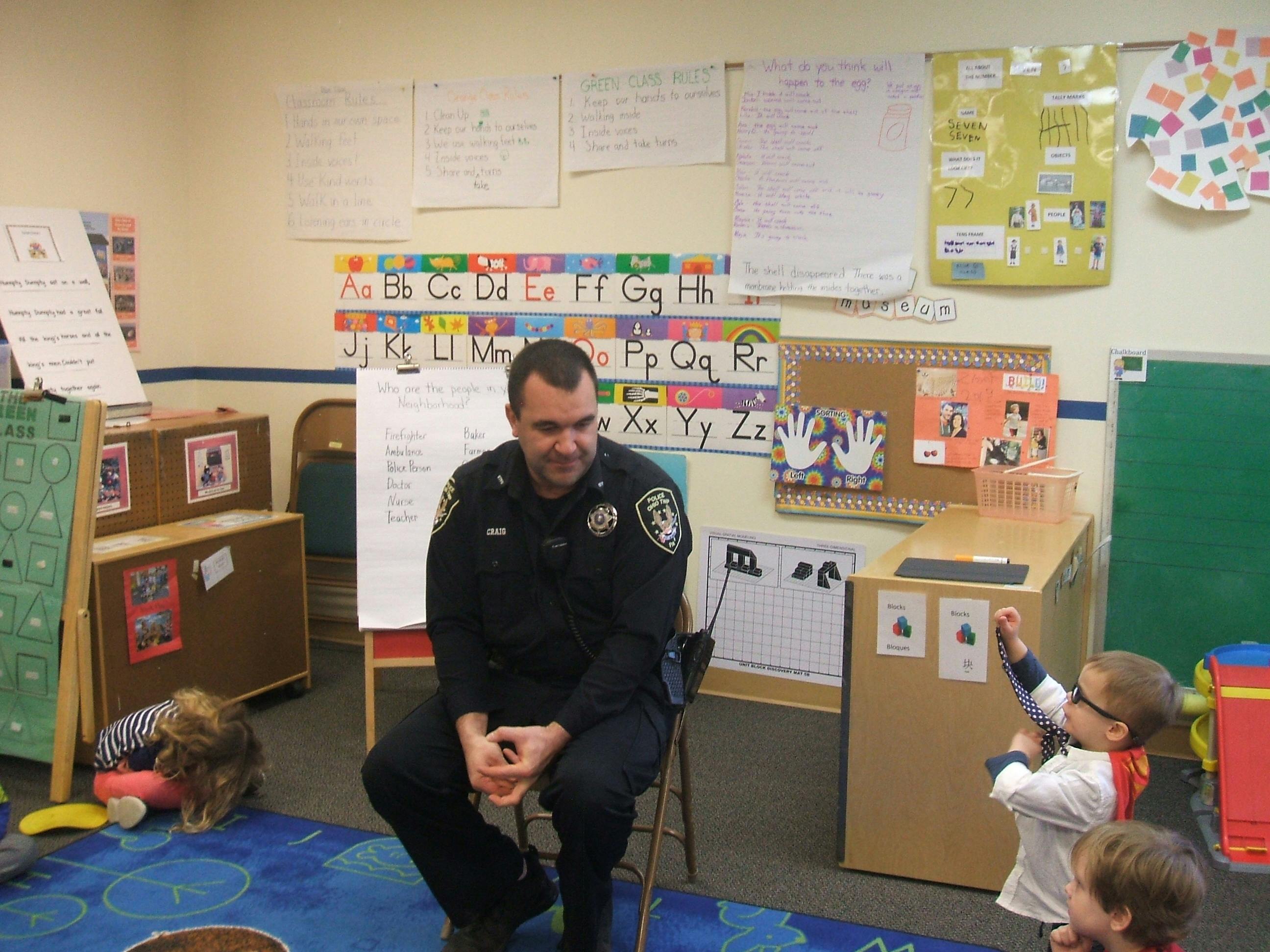 Police officer sitting in a classroom with children