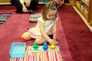 Child playing with colorful stacking toys on a rug