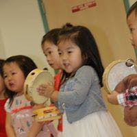 Children holding and playing tambourines