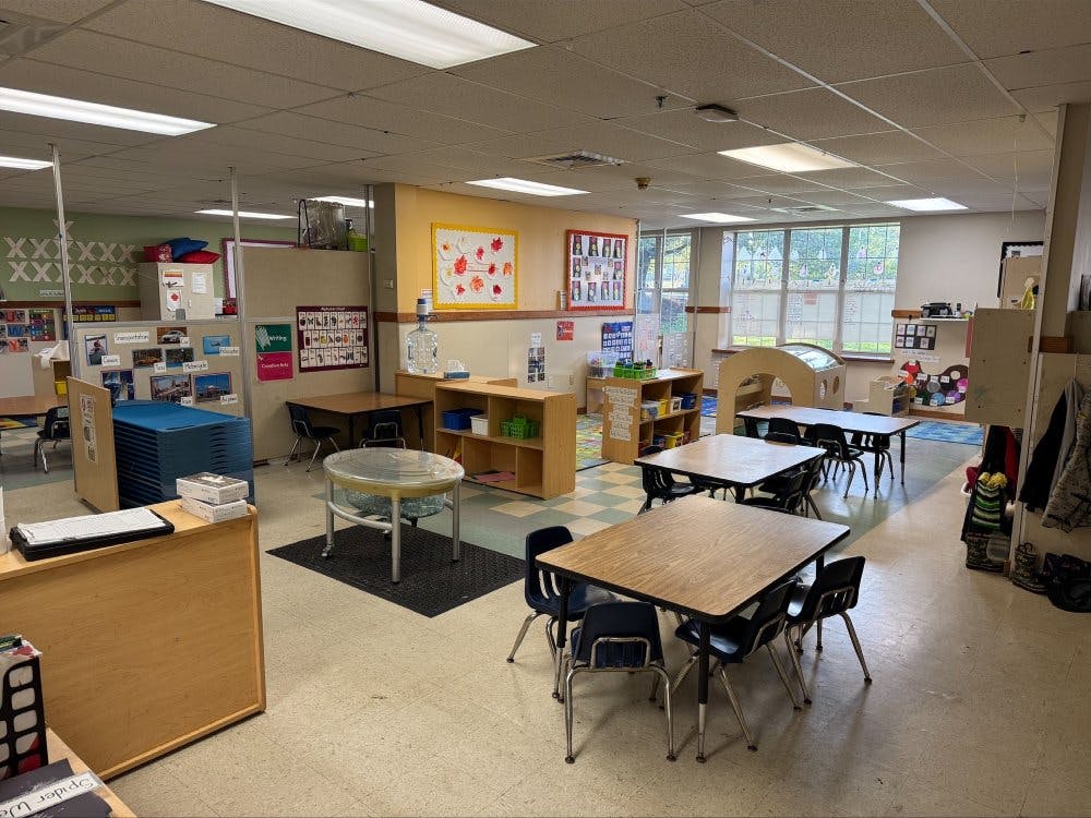 Classroom with tables and chairs, learning materials, and natural light from windows