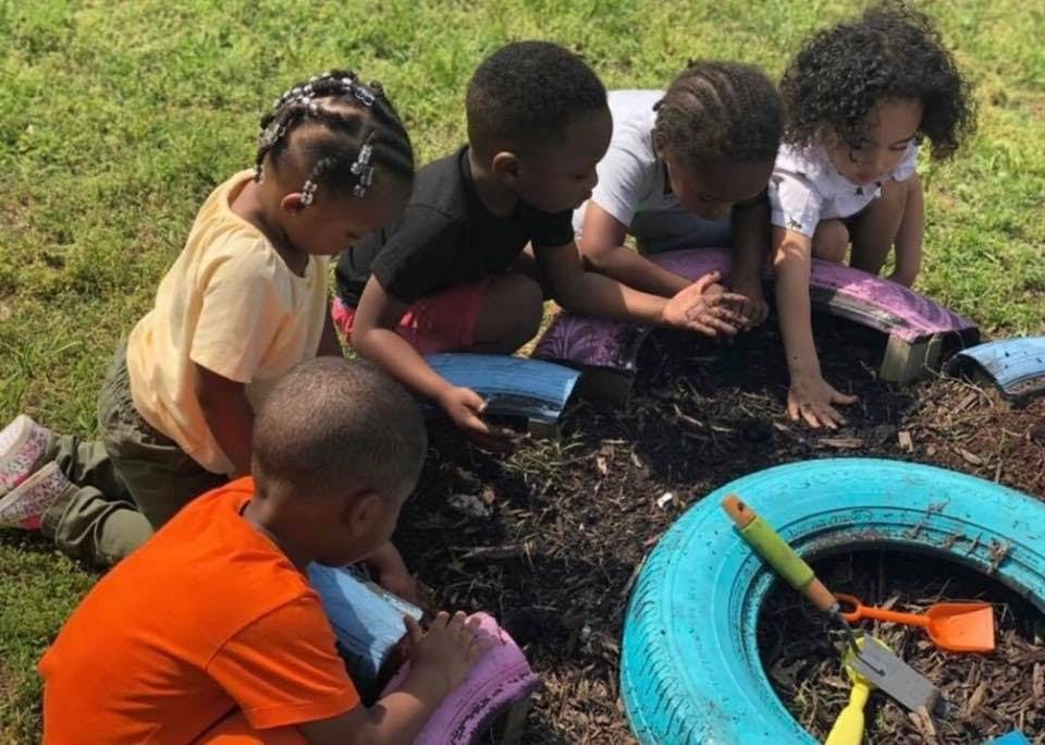 Children playing in dirt with small tools