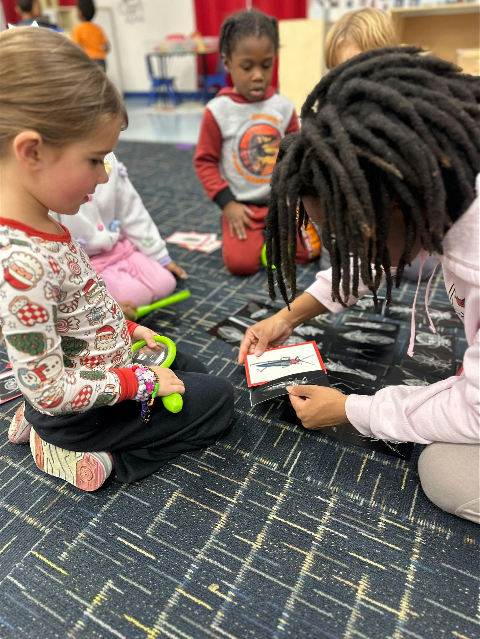 Adult and children sitting on floor looking at cards