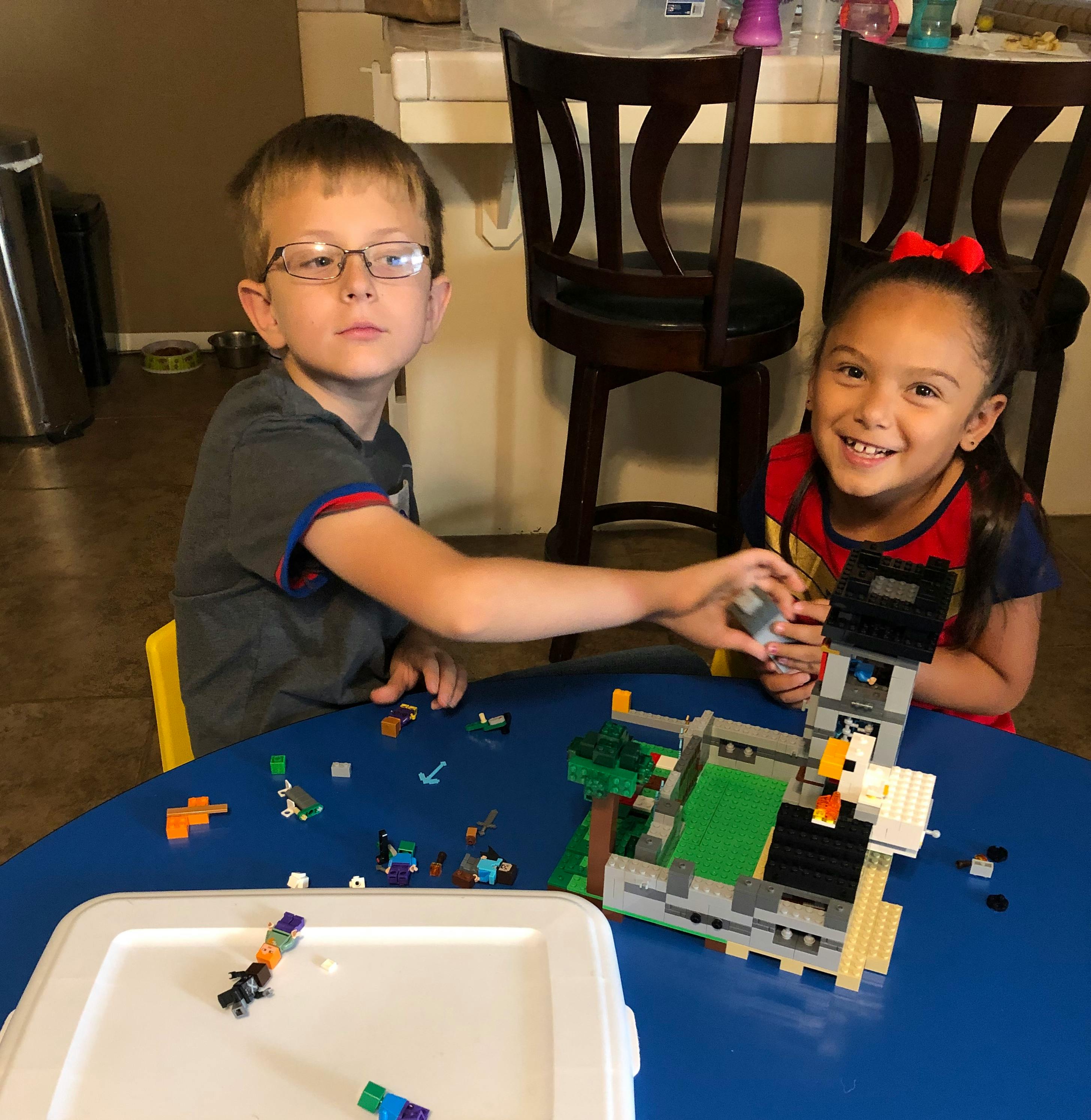 Two children playing with building blocks at a table